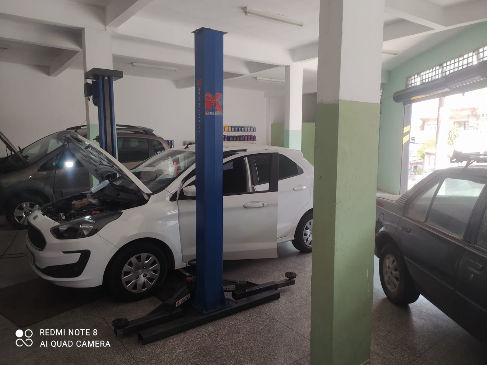 Interior da mecânica com carros na frente